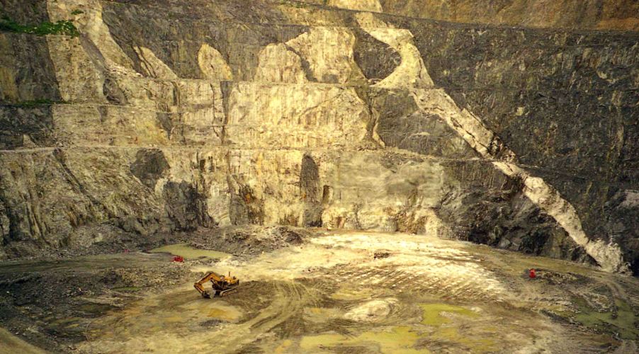 Un sito minerario con un grande scavatore per rocce.